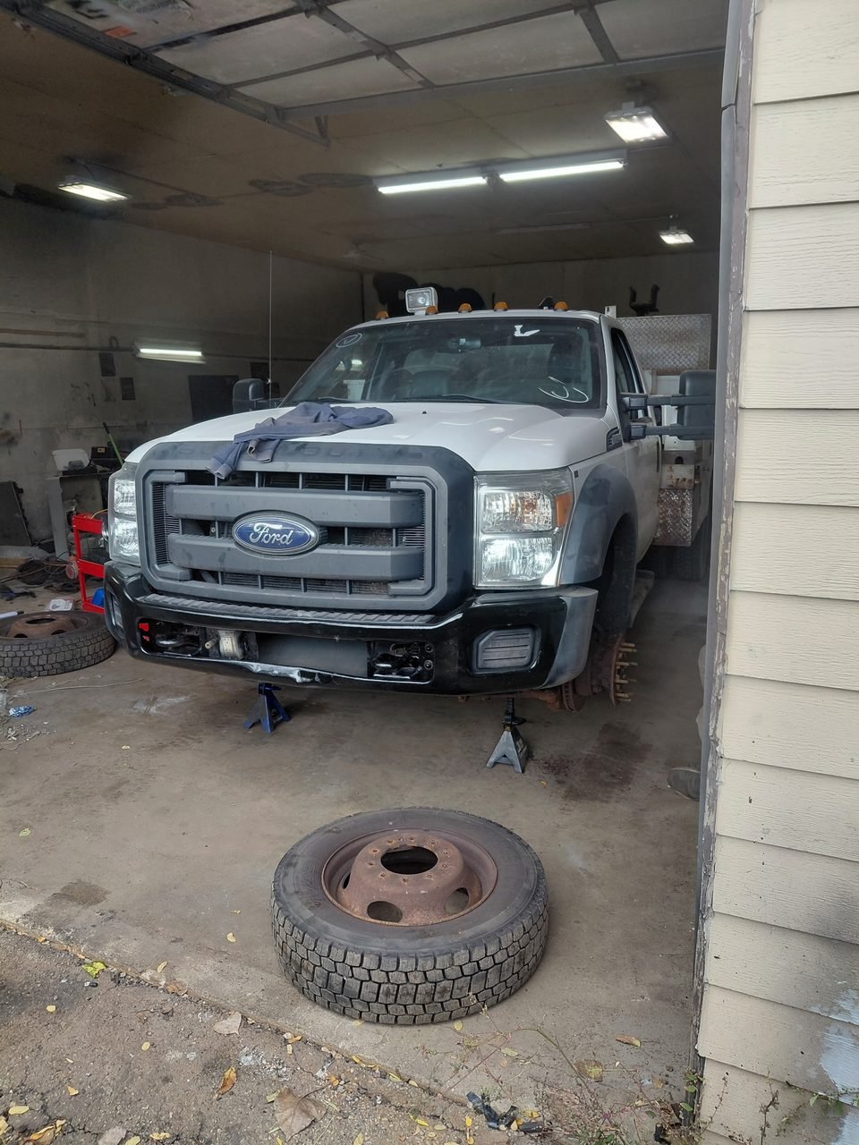 F-450 in the shop with a wheel removed and placed on the floor during work